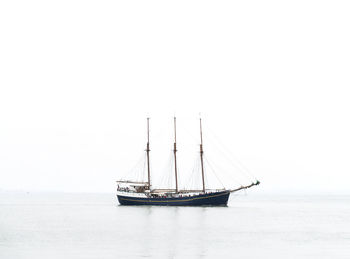 Sailboat sailing on sea against clear sky