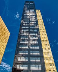 Low angle view of modern buildings against blue sky