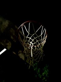 Low angle view of basketball hoop at night