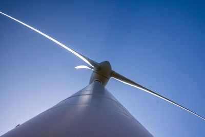 Low angle view of wind turbine against blue sky