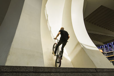 Man riding bicycle on staircase of building