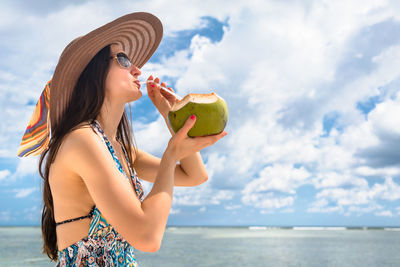 Young woman holding coconut in her tropical vacation