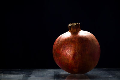 Ripe red pomegranate on the table, black background