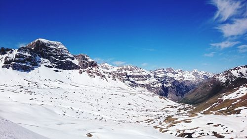 Scenic view of snowcapped mountains against blue sky