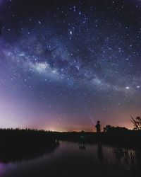 Scenic view of lake against sky at night