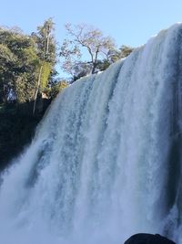 Scenic view of waterfall against sky