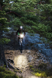 Man cycling through forest