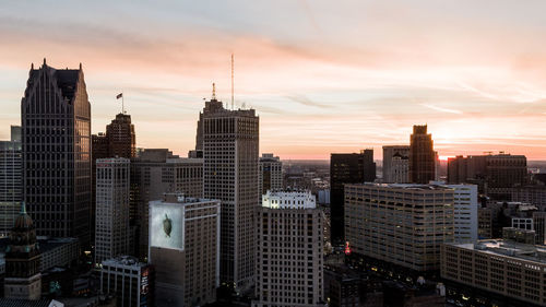 Skyscrapers in city against cloudy sky