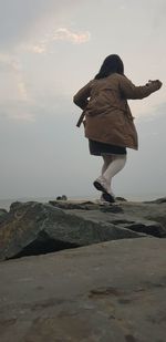 Rear view of woman walking on beach