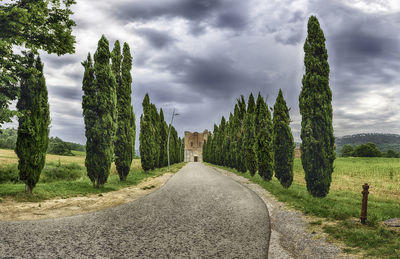 Panoramic view of road amidst field against sky