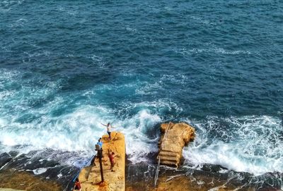 High angle view of waves splashing on rocks