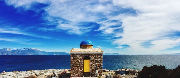 Scenic view of sea by building against sky