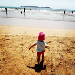 Rear view of baby girl walking on beach