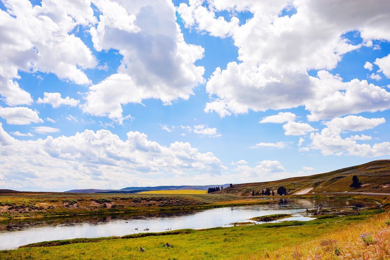 sky, water, cloud - sky, tranquil scene, tranquility, scenics, grass, beauty in nature, landscape, cloud, lake, nature, cloudy, river, field, mountain, idyllic, day, non-urban scene, no people