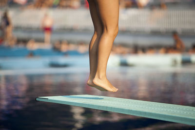 Low section of woman jumping diving board