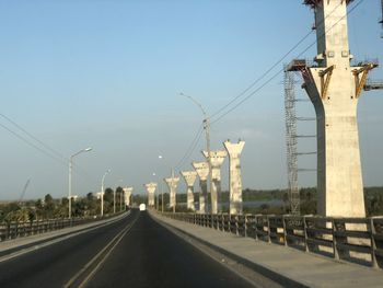 Road by bridge against sky in city