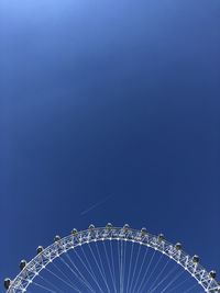 Low angle view of ferris wheel against blue sky