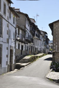 Road amidst buildings against sky in city