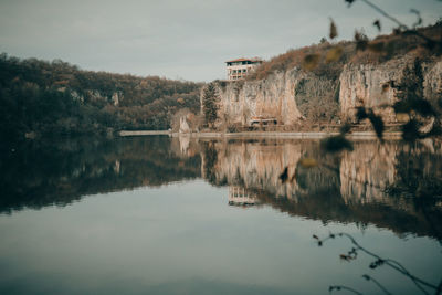 Reflection of building in lake against sky