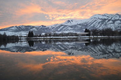 Scenic view of lake and mountains against sky during sunset