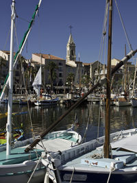 Boats moored at harbor against buildings in city