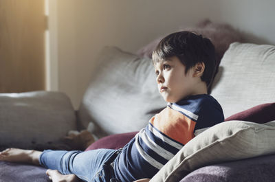 Boy sitting on sofa at home