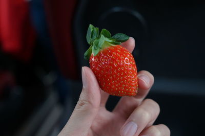 Close-up of hand holding strawberry