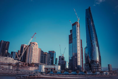 Modern buildings in city against blue sky