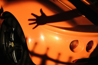 Close-up of orange shadow on black car