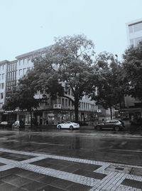 Cars on street in city against clear sky