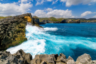 Scenic view of rocks in sea against sky