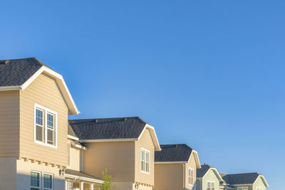 Low angle view of buildings against clear blue sky