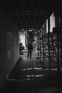 Rear view of man standing on bridge against building