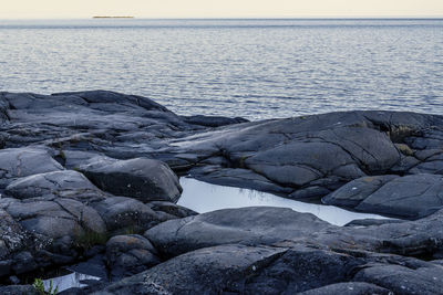 Rocks in sea against sky