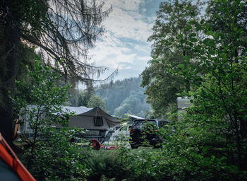 House amidst trees and buildings against sky