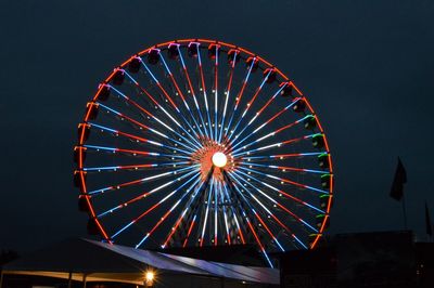 Low angle view of illuminated ferris wheel against sky at night