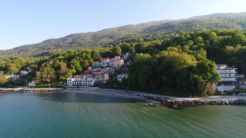 Scenic view of river by buildings against sky