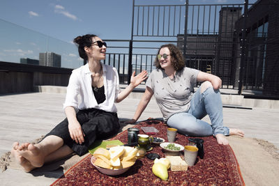 Woman with below-elbow amputation with her friend having a healthy meal on the roof