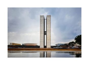 Digital composite image of monument and buildings against sky