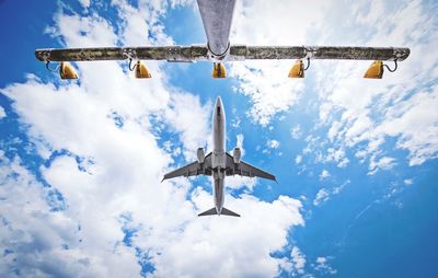 Low angle view of airplane flying against sky