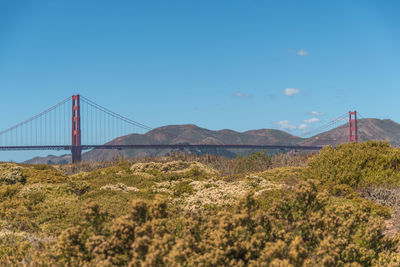 View of suspension bridge against cloudy sky