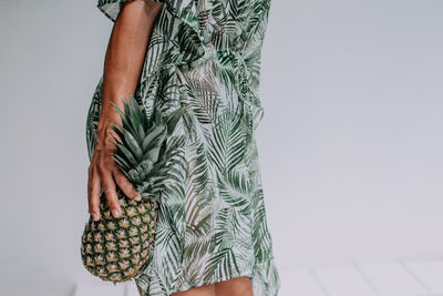 Midsection of woman holding umbrella standing outdoors