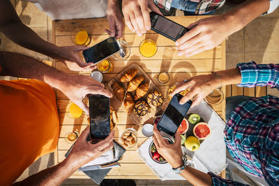 Directly above shot of people photographing food with mobile phone on table