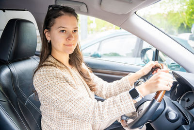 Portrait of young woman sitting in car