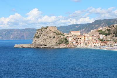 Scenic view of sea by buildings against sky