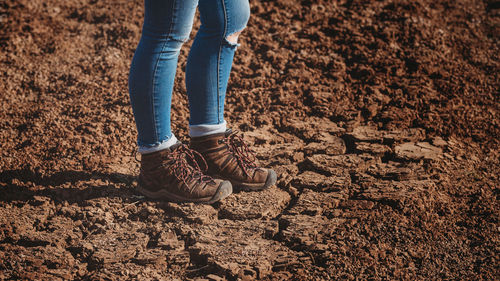 Low section of person standing on mud