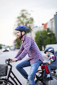 Man cycling with baby son, vastervik, smiland, sweden