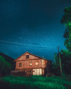 House on field against sky at night