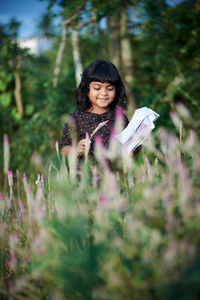 Portrait of a smiling young woman holding plants