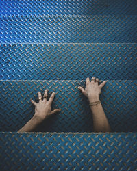 Cropped hands of person on metallic steps
